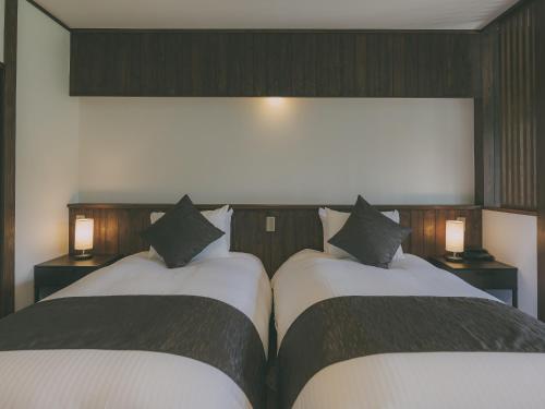 two beds sitting next to each other in a room at Chalet Shiga in Yamanouchi