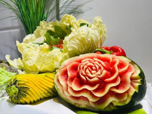 a watermelon with a flower on it next to a pile of vegetables at Ocean Pearl Hotel Phu Quoc in Phu Quoc