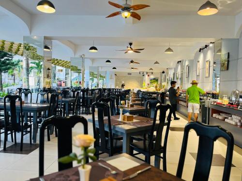 a restaurant with tables and chairs and people in the background at Ocean Pearl Hotel Phu Quoc in Phu Quoc