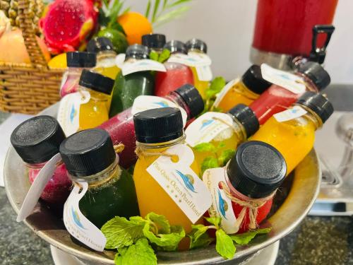 a bowl filled with bottles of honey and fruit at Ocean Pearl Hotel Phu Quoc in Phu Quoc