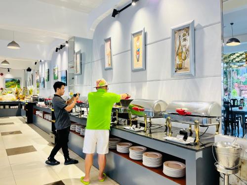 two people preparing food in a restaurant kitchen at Ocean Pearl Hotel Phu Quoc in Phu Quoc