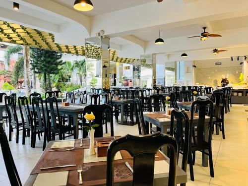 a restaurant with tables and chairs in a room at Ocean Pearl Hotel Phu Quoc in Phu Quoc