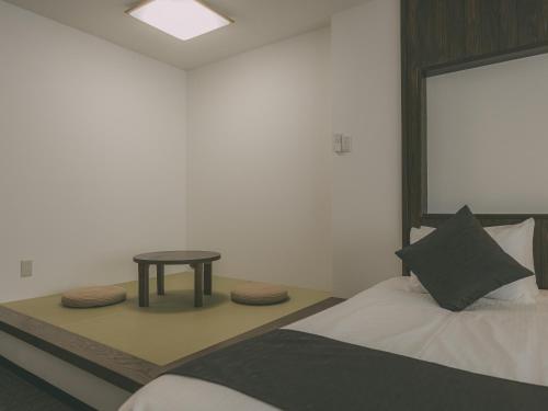 a bedroom with a bed and a small table at Chalet Shiga in Yamanouchi