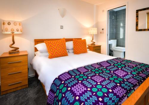 a bedroom with a large bed with colorful pillows at Hillview in Llanbedrog
