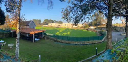 a large yard with a green fence and a building at Quinta Lourenca - Vila do Conde in Vilar