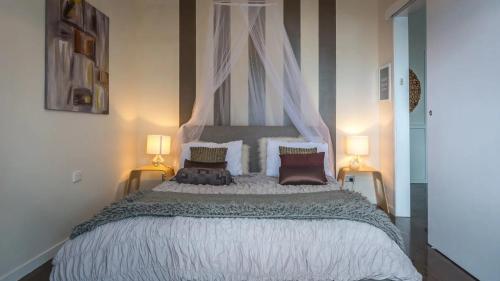 a large bed in a bedroom with two lamps at Beachfront- The Art Cottage- Pet Friendly in Vincentia
