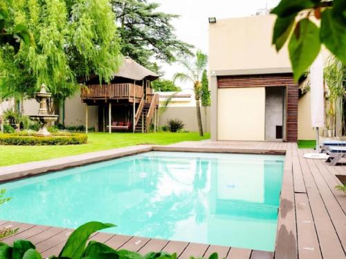 a swimming pool in front of a house at One O Eight Boutique Hotel in Benoni