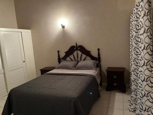 a bedroom with a bed with a black bedspread at Paradise View Hilltop 5 Bedroom Residence in Dickenson Bay