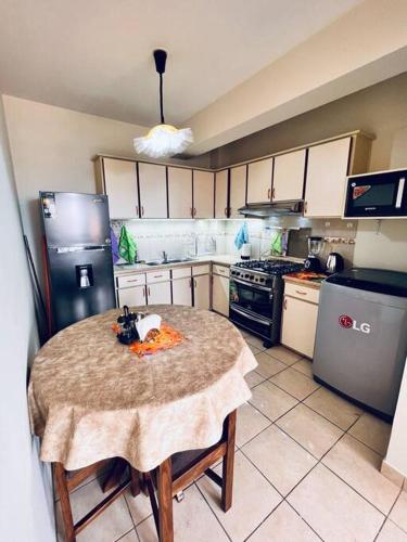 a small kitchen with a table and a refrigerator at El Sosiego en Cochabamba in Cochabamba