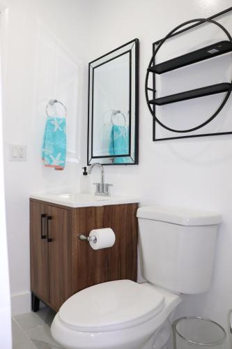 a bathroom with a white toilet and a sink at Flamingo Beach House in Dania Beach