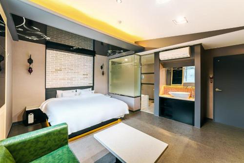 a bedroom with a large bed and a bathroom at Hotel Ssome Jeongkwan in Busan