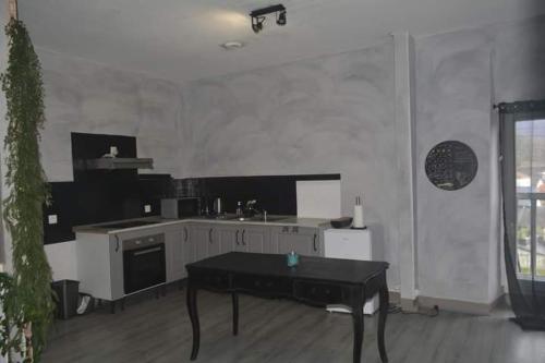 a kitchen with a table in the middle of a room at Gîte LORLAVIE in Arudy