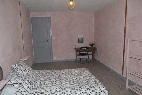 a bedroom with a bed and a table and a desk at Gîte LORLAVIE in Arudy