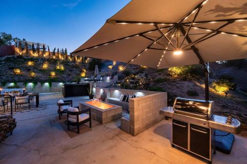 eine Terrasse mit einer Bar im Freien mit einem Sonnenschirm in der Unterkunft Luxury Getaway: Hot Tub,Pool Table,Fire Pit in Palmdale