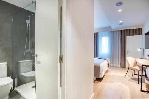 una habitación de hotel con una cama y un baño en Hotel Costabella, en Girona