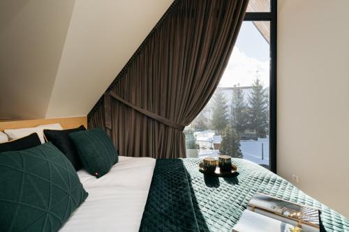 1 dormitorio con cama y ventana grande en Skyline Villa by LoftAffair, en Kościelisko