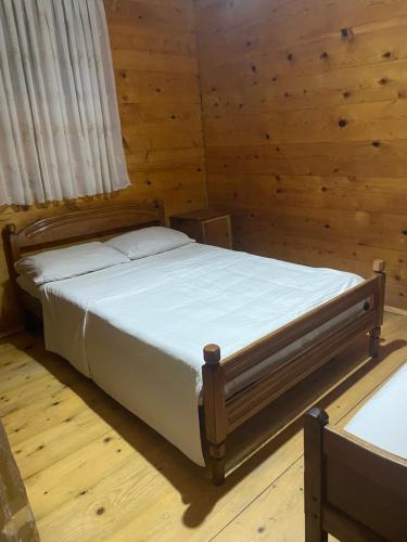 ein Schlafzimmer mit einem Bett in einem Holzzimmer in der Unterkunft Nika House in Ureki