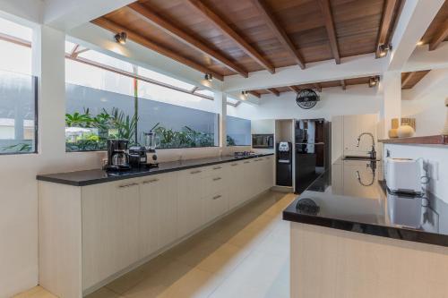 eine große Küche mit weißen Schränken und einem großen Fenster in der Unterkunft Villa B in Seminyak