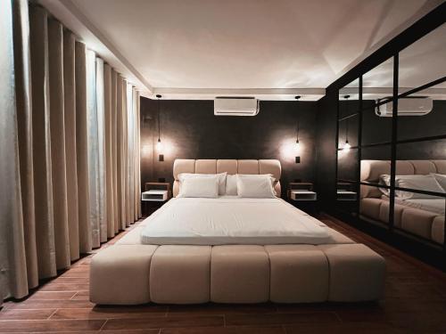 een slaapkamer met een groot wit bed met zwarte muren bij LUXURY PALACE POBLADO MANILA in El Poblado