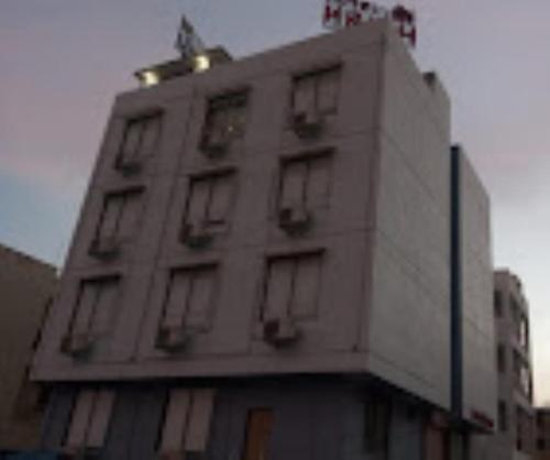 a tall white building with windows on top of it at Hotel Krish , Somnath in Somnath