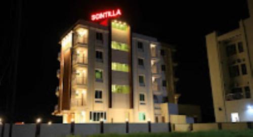 a building with a neon sign on top of it at Hotel Krish , Somnath in Somnath