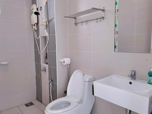 a white bathroom with a toilet and a sink at JB Bukit Indah Skyloft Suites in Johor Bahru