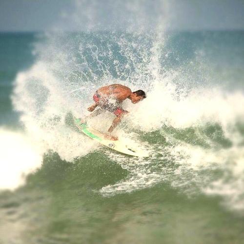 a man riding a wave on a surfboard in the ocean at Genta House in Kuta