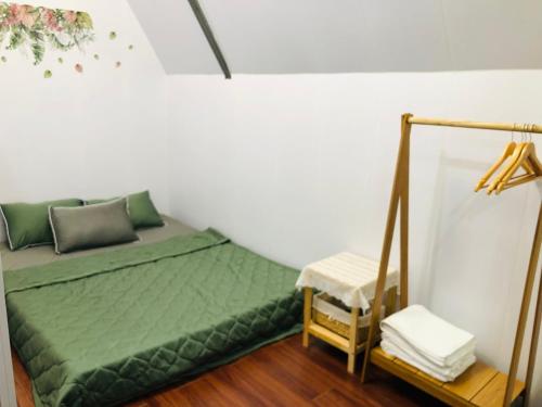 a bedroom with a green bed in a room at Cóc Retreat Mỹ Tho City in My Tho