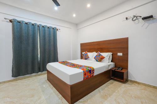 um quarto com uma cama grande e uma janela em FabHotel Tree Suites em Bangalore