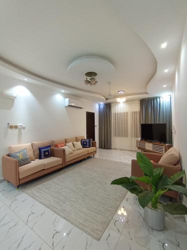 ein Wohnzimmer mit Sofas und einem Flachbild-TV in der Unterkunft شقة المعبيلة الجنوبية in Ghursheba