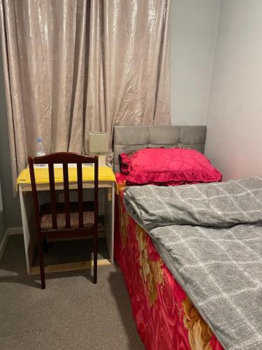 um quarto com uma secretária e uma cadeira ao lado de uma cama em High View em Swindon