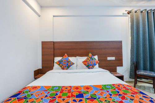 a bedroom with a bed with a colorful comforter at FabHotel Tree Suites - Nr Reva University in Bengaluru