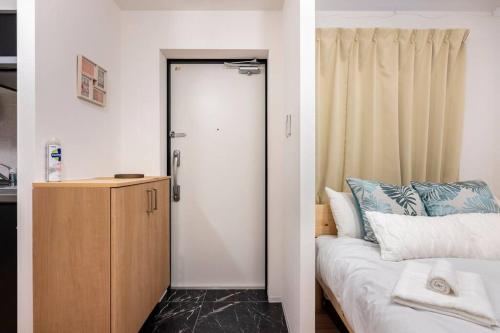 um quarto com uma porta que leva a uma cama em アンドステイ池袋4丁目 em Tóquio