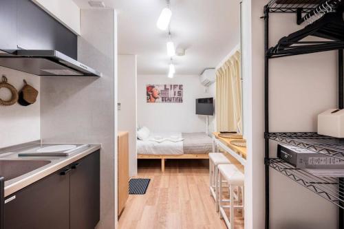 um quarto com uma cozinha e um quarto com uma cama em アンドステイ池袋4丁目 em Tóquio