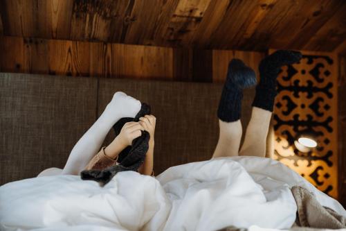 a person laying in bed with their feet in socks at Biohof Ebengut in Maria Alm am Steinernen Meer