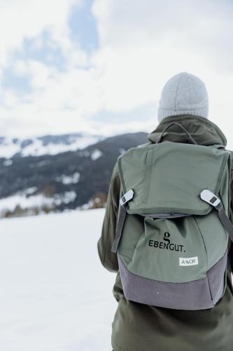 a person with a backpack looking out at the snow at Biohof Ebengut in Maria Alm am Steinernen Meer