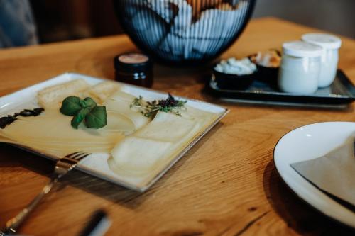 a plate of cheese on a wooden table at Biohof Ebengut in Maria Alm am Steinernen Meer