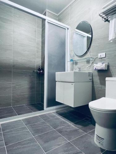 a bathroom with a shower and a sink and a toilet at 秀舍民宿Showhouse in Hengchun