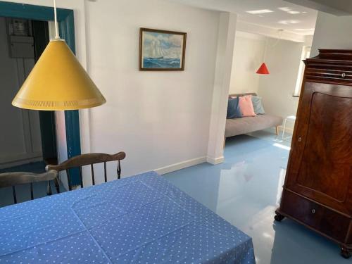 ein Wohnzimmer mit einem blauen Tisch und einer gelben Lampe in der Unterkunft Skønt fiskerhus. Tæt på by, havn og havet in Marstal