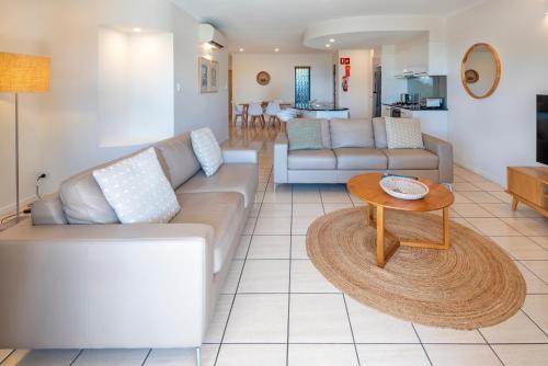 a living room with a couch and a table at Anchorage Apartments on Hamilton Island by HIHA in Hamilton Island