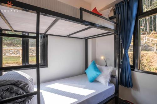 a bunk bed in a room with two windows at Zostel Rinchenpong (Pelling) in Rinchingpong