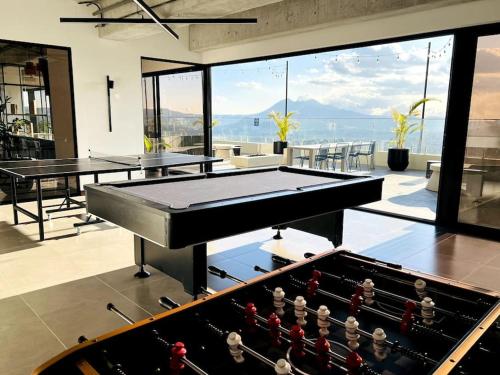 a ping pong table in a room with a pool table at Urban Gem: Comfort, Style, Views. Apartment close to the AIRPORT in Guatemala