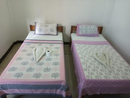 two beds sitting next to each other in a room at Ashok Homestay in El Nido