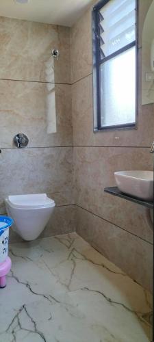 艾哈邁達巴德的住宿－Hotel Gurukul INN，一间带水槽和卫生间的浴室以及窗户。