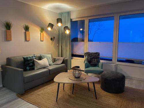 a living room with a couch and a table at Ferienwohnung Sundkieker Fehmarn in Fehmarn