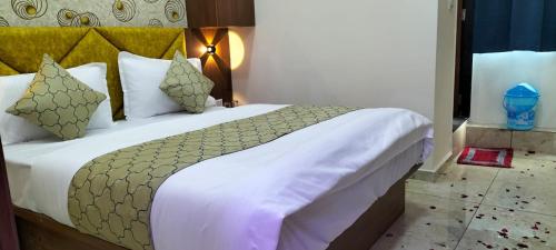 艾哈邁達巴德的住宿－Hotel Gurukul INN，卧室配有一张带白色床单和枕头的大床。