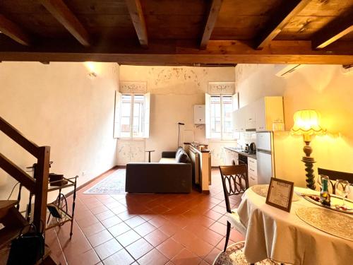 a living room with a table and a kitchen at Renaissance Suite in Ferrara