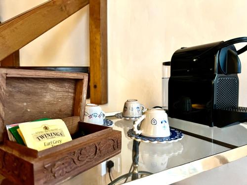 a glass table with a microwave and a coffee maker at Renaissance Suite in Ferrara