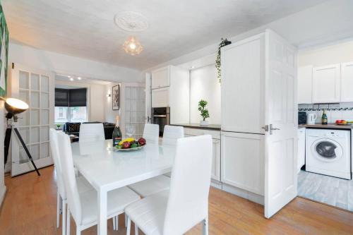 a kitchen and dining room with a white table and chairs at 3 Bed House - 8 Guests - Parking - Top Rated -162S - Netflix - Wifi - Smart TV in Birmingham