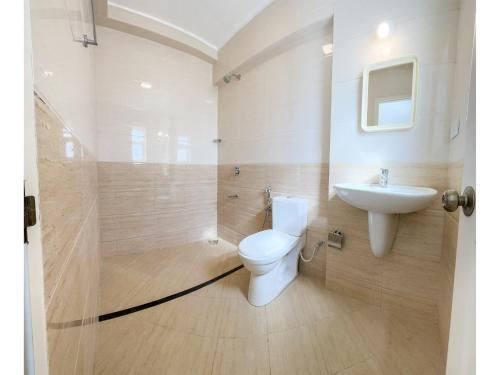 a bathroom with a toilet and a sink at B&F Meadows - Your Premier Apartment Hotel in Revora
